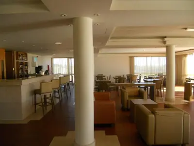 a restaurant with columns and chairs and a bar at INATEL Porto Santo in Porto Santo