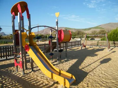 a playground with a yellow slide and a slideintend at INATEL Porto Santo in Porto Santo