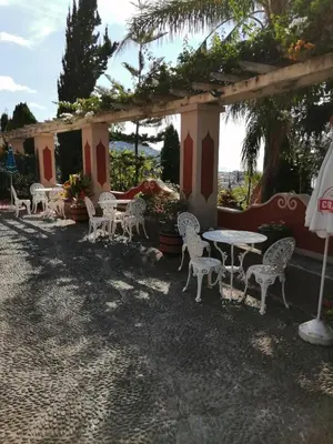 a group of tables and chairs under a pergola at A Casa Do Caseiro in Funchal