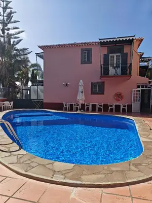 a villa with a swimming pool in front of a house at A Casa Do Caseiro in Funchal