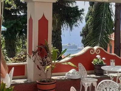 a patio with a table and chairs and a view of the ocean at A Casa Do Caseiro in Funchal