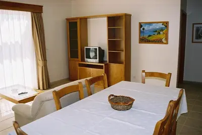a dining room with a table and a television at Paraiso Dourado in Porto Santo