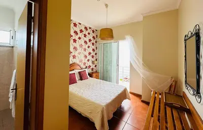 a bedroom with a bed and a window at Villa Babel in Garajau