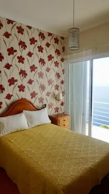 a bedroom with a bed with a flower patterned wall at Villa Babel in Garajau