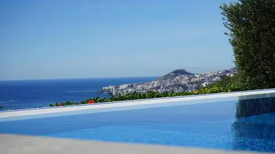 a swimming pool with a view of the ocean at Villa Babel in Garajau