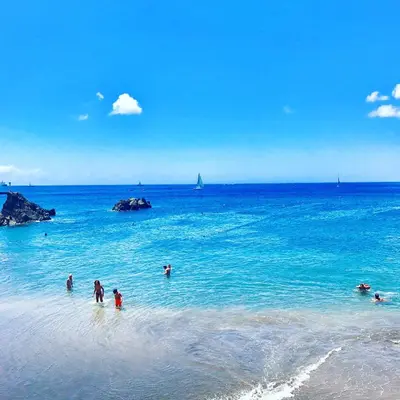a group of people in the water at the beach at Villa Babel in Garajau