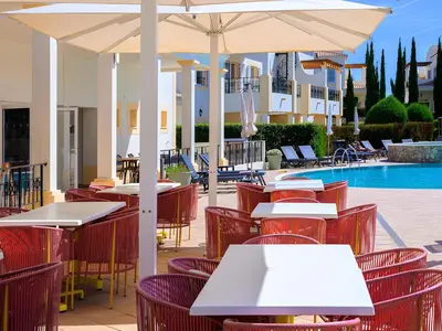 an outdoor patio with tables and chairs and a pool at NAU Salema Beach Village in Salema
