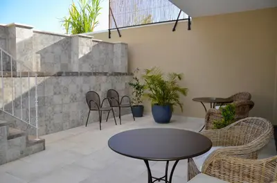 a patio with two tables and chairs and plants at Vila Toca in Funchal