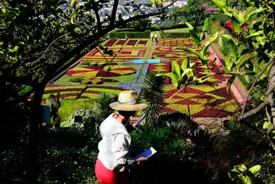a man in a hat looking at a garden at Vila Toca in Funchal