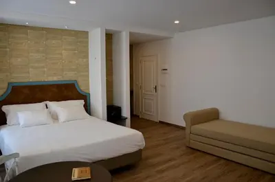 a bedroom with a white bed and a table and chairs at Vila Toca in Funchal