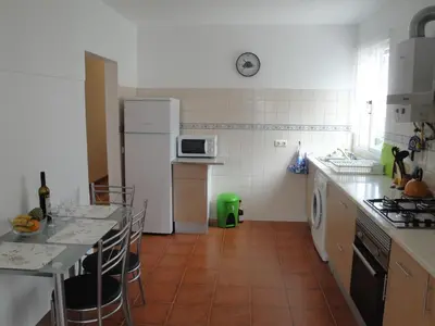 a kitchen with a white refrigerator and a table with chairs at Apartment Alameda with Sea View in Machico