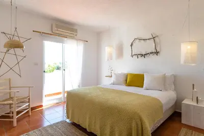a bedroom with a bed with a yellow blanket at Utopia in Aljezur