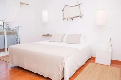 a white bed with white sheets and pillows in a room at Utopia in Aljezur