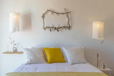 a bed with a yellow and white pillow on it at Utopia in Aljezur