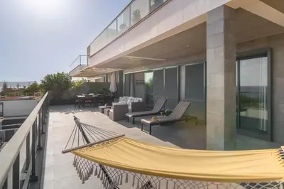 a hammock on the balcony of a house at Casa da Maresia by An Island Apart in Porto Santo