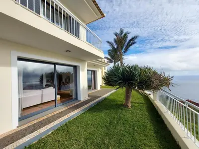 a house with a balcony with a view of the ocean at The best sea view in Madeira - Casa Farol in Fajã da Ovelha