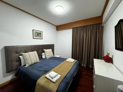a bedroom with a bed with blue sheets and a window at Ilheus 1 in Funchal
