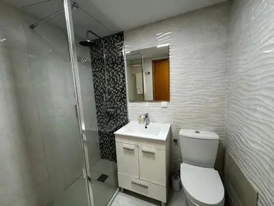 a bathroom with a toilet and a sink and a shower at Ilheus 1 in Funchal