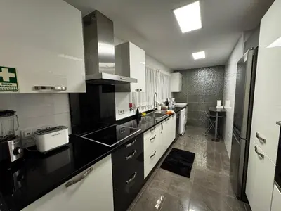 a kitchen with black and white counters and a sink at Ilheus 1 in Funchal