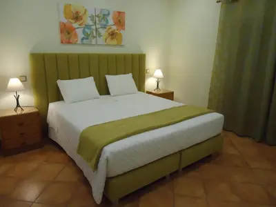 a bedroom with a large bed with two night stands at Canavial I & II Apartamentos in Lagos