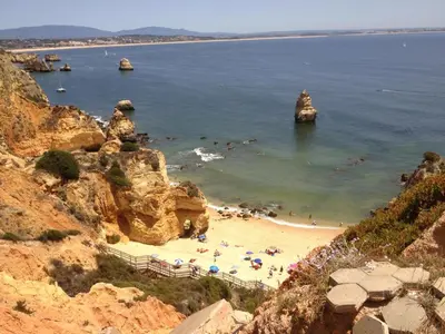 a beach with a bunch of people in the water at Canavial I & II Apartamentos in Lagos