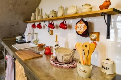 a kitchen counter with pots and utensils on it at Casas da Levada in Ponta do Pargo
