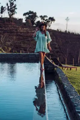 a girl in a dress walking in the water at Casas da Levada in Ponta do Pargo