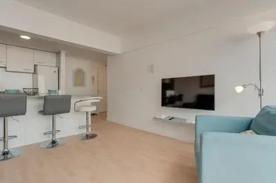 a living room with a blue couch and a kitchen at Arriaga apartment in Funchal