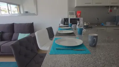 a table with plates and utensils on it in a kitchen at Arriaga apartment in Funchal