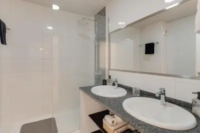 a bathroom with two sinks and a mirror at Arriaga apartment in Funchal
