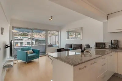 a kitchen and living room with a view of a city at Arriaga apartment in Funchal