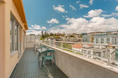 a balcony with a table and chairs on a building at Arriaga apartment in Funchal