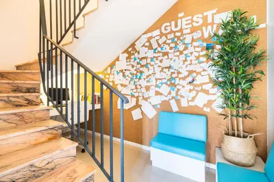 a stairway with a blue chair and a wall with a guess mural at Casa Azul Sagres - Rooms & Apartments in Sagres