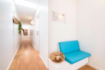 a room with a blue chair and a hallway at Casa Azul Sagres - Rooms & Apartments in Sagres