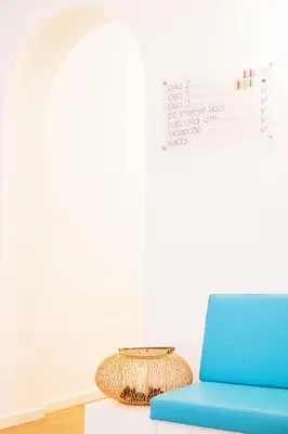 a living room with a blue chair and a table at Casa Azul Sagres - Rooms & Apartments in Sagres