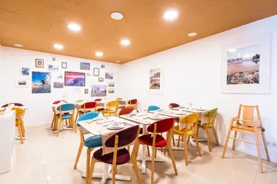 a dining room with tables and chairs and pictures on the wall at Casa Azul Sagres - Rooms & Apartments in Sagres
