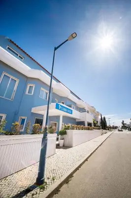 a street light with a street sign in front of a building at Casa Azul Sagres - Rooms & Apartments in Sagres