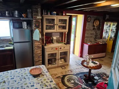 a kitchen with a wooden table and a white refrigerator at Casa d'Alegria Madeira Island in Ribeira Brava