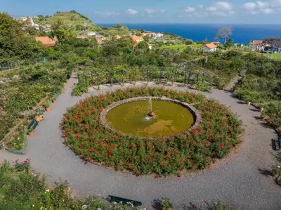a garden with a pond with flowers in it at Pestana Quinta do Arco Nature & Rose Garden Hotel in Arco de São Jorge