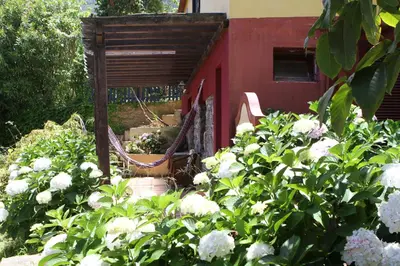 a bedroom with a bed and a red couch at Pestana Quinta do Arco Nature & Rose Garden Hotel in Arco de São Jorge