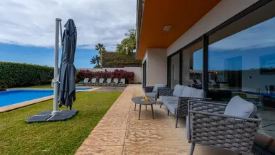 a bedroom with a large white bed and a large window at Villa Vitoria - by LovelyStay in Funchal