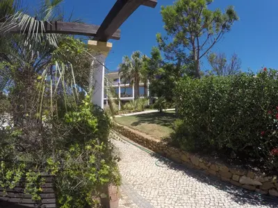 a pathway leading to a house with trees and bushes at Luzmar Villas in Luz
