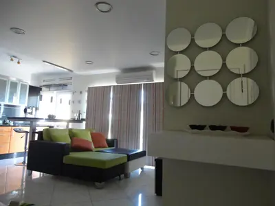 a living room with a couch and mirrors on the wall at Apartamento Raio de Sol in Caniço