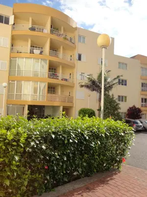 an apartment building with a bush in front of it at Apartamento Raio de Sol in Caniço
