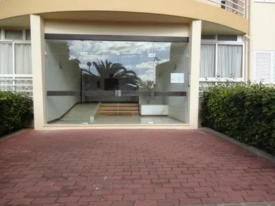 a glass entrance to a building with a palm tree in it at Apartamento Raio de Sol in Caniço