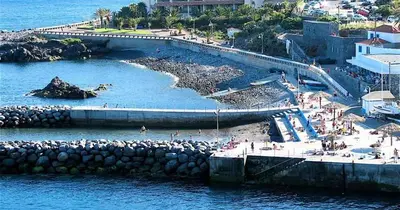 a group of people on a beach near the water at Apartamento Raio de Sol in Caniço