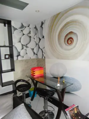 a dining room with a table and two stools at Apartamento Raio de Sol in Caniço