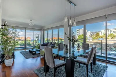 a dining room with a glass table and chairs and large windows at Monumental Residence apartment with pool by HR Madeira in Funchal