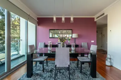 a dining room with a purple wall and a table and chairs at Monumental Residence apartment with pool by HR Madeira in Funchal