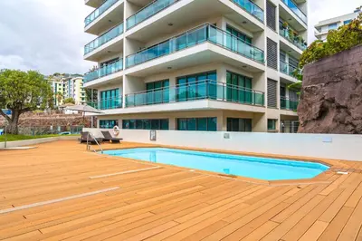 a swimming pool in front of a building at Monumental Residence apartment with pool by HR Madeira in Funchal